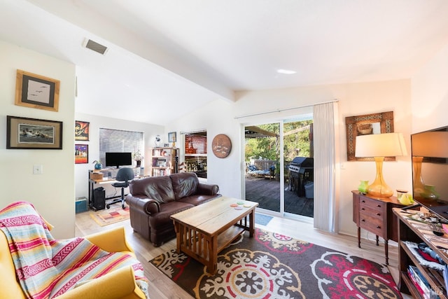 living room with visible vents, wood finished floors, and lofted ceiling with beams