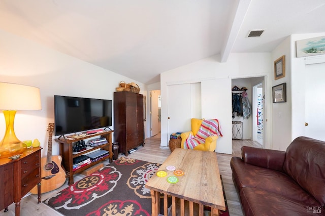 living room featuring vaulted ceiling with beams and hardwood / wood-style flooring