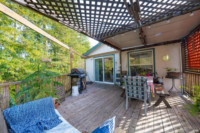 deck featuring outdoor dining area, grilling area, and a pergola