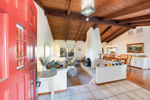 living room featuring wood ceiling, a chandelier, lofted ceiling with beams, and light tile patterned floors