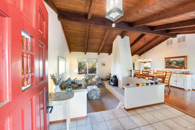living room with light tile patterned floors, an inviting chandelier, wooden ceiling, and visible vents
