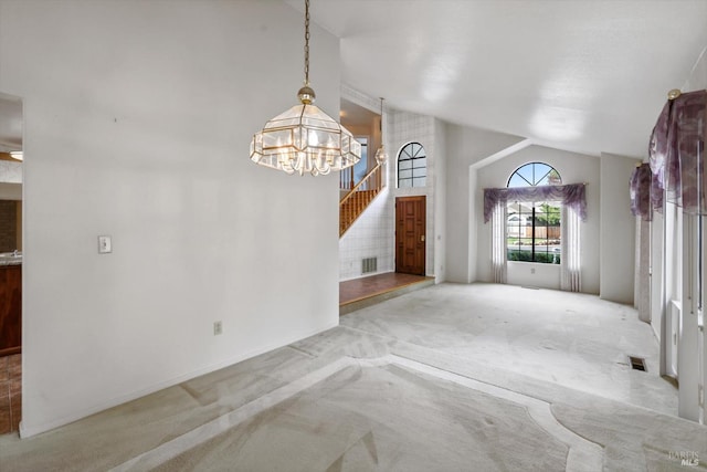 unfurnished living room featuring light colored carpet, vaulted ceiling, and a notable chandelier