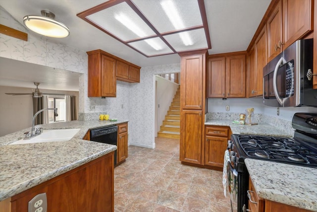 kitchen featuring sink, light stone counters, ceiling fan, and black appliances