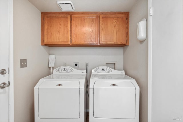 washroom with washer and clothes dryer and cabinets