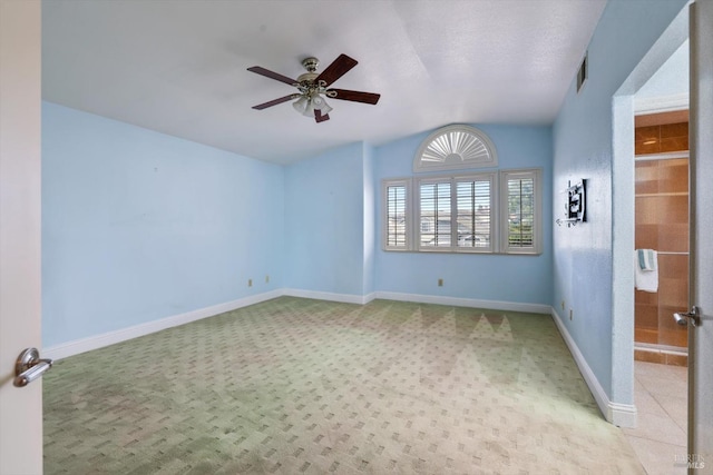 carpeted spare room with ceiling fan and lofted ceiling