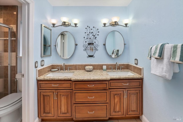 bathroom with a shower with door, vanity, and toilet