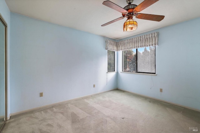 carpeted spare room featuring ceiling fan