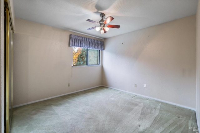 spare room with ceiling fan and light colored carpet