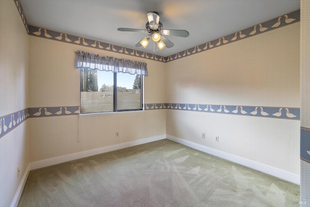 carpeted spare room featuring ceiling fan