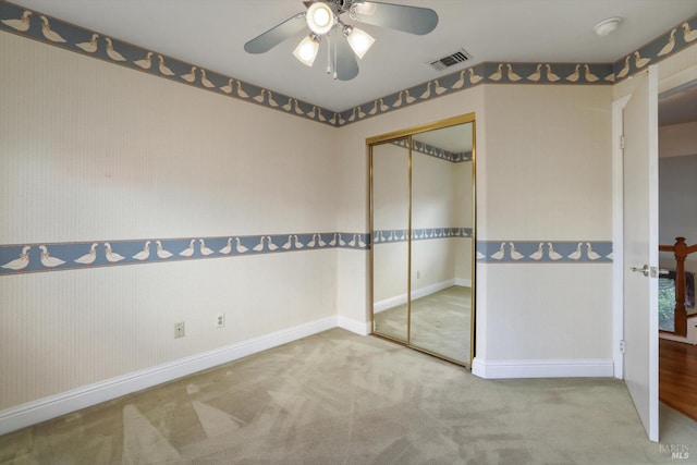 unfurnished bedroom with carpet, a closet, and ceiling fan