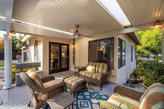 wooden terrace with ceiling fan and an outdoor hangout area