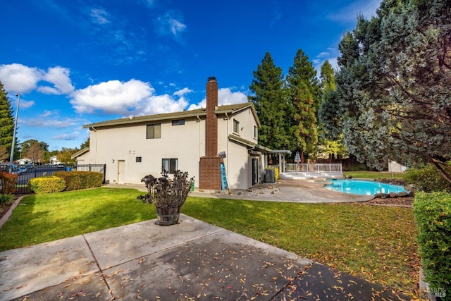 back of property with a yard, a patio, a fenced in pool, and central air condition unit