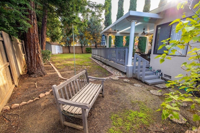 view of yard with a wooden deck and a shed