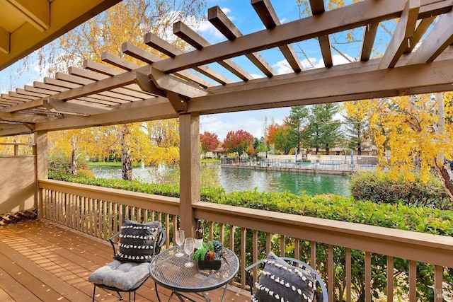 deck featuring a water view and a pergola