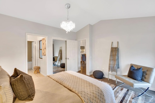bedroom featuring vaulted ceiling, a notable chandelier, baseboards, and connected bathroom
