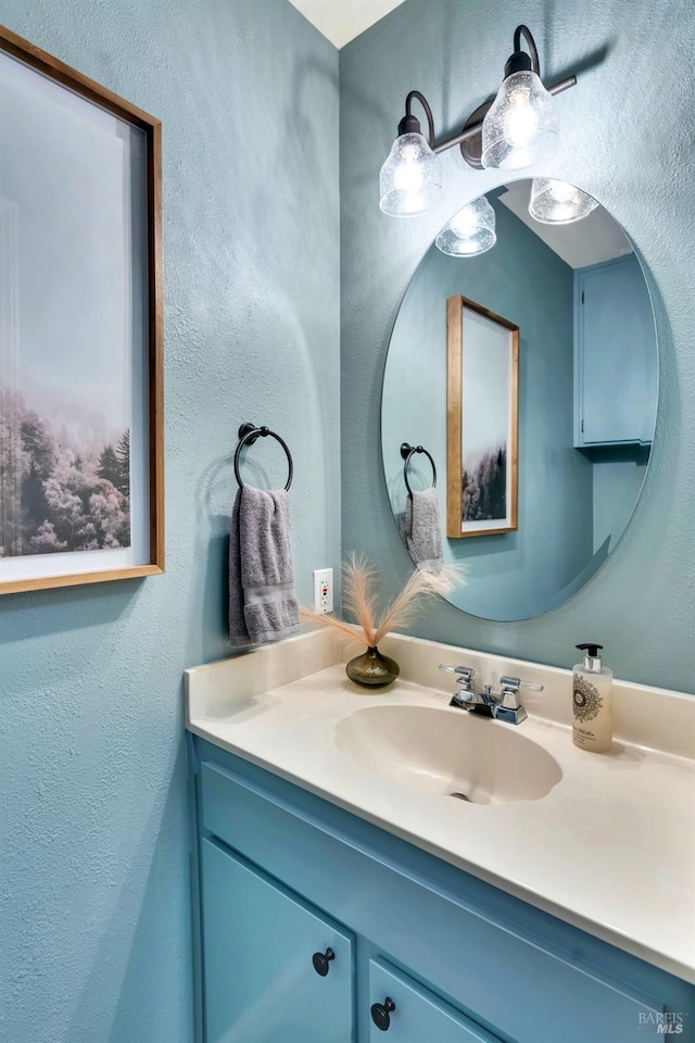 bathroom with vanity and a textured wall