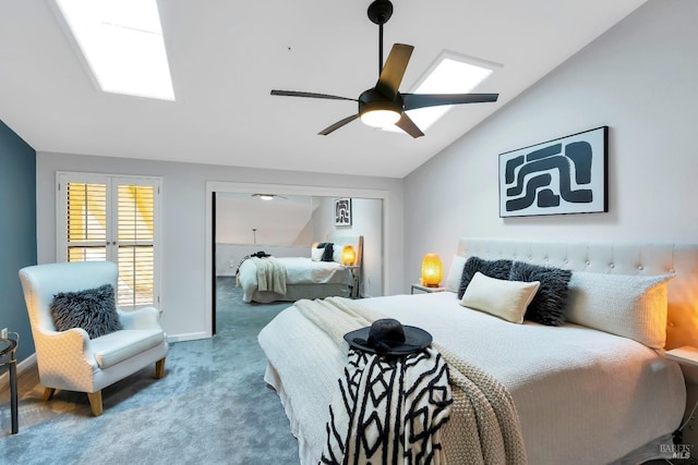 carpeted bedroom featuring vaulted ceiling with skylight, a ceiling fan, and baseboards
