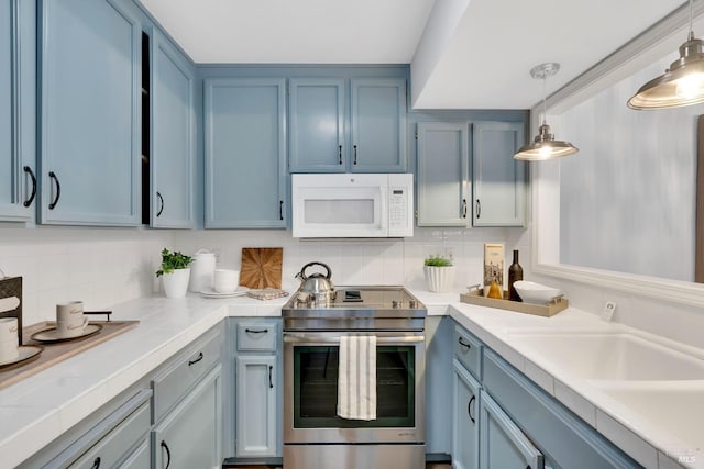 kitchen with sink, hanging light fixtures, blue cabinets, backsplash, and stainless steel range with electric cooktop