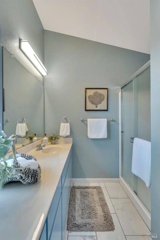 full bath featuring marble finish floor, vanity, a shower stall, and baseboards