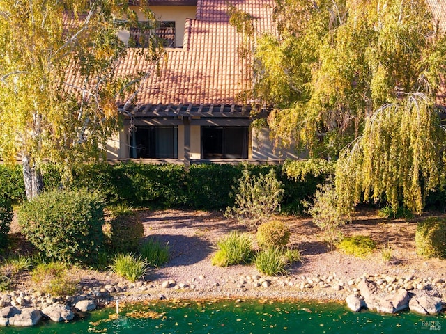view of property exterior with stucco siding and a tile roof
