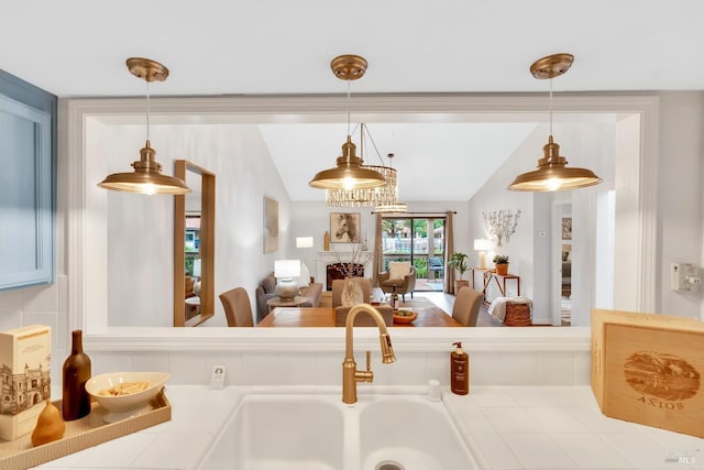 kitchen featuring hanging light fixtures, lofted ceiling, tile countertops, and a sink