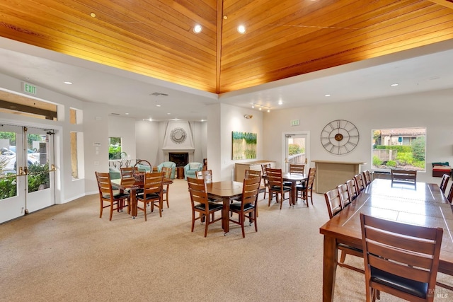 carpeted dining space featuring recessed lighting, french doors, wood ceiling, and a fireplace