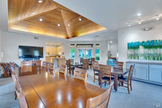 dining room with visible vents, light colored carpet, wood ceiling, and a tray ceiling