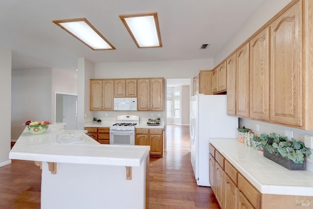 kitchen featuring light brown cabinetry, dark hardwood / wood-style flooring, white appliances, sink, and tile counters