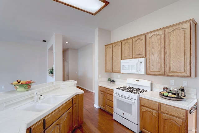 kitchen featuring light brown cabinetry, white appliances, sink, dark hardwood / wood-style floors, and tile counters