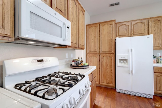 kitchen with tile countertops, light brown cabinets, dark hardwood / wood-style flooring, and white appliances