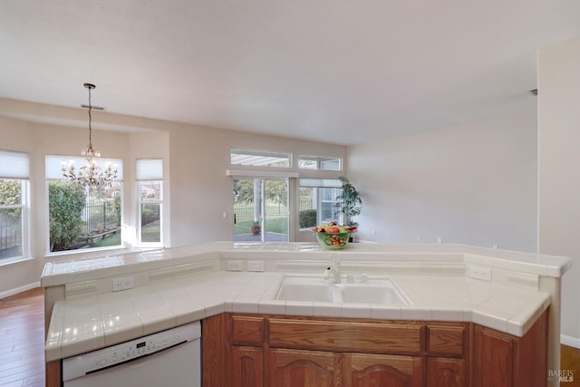 kitchen with tile countertops, dark hardwood / wood-style flooring, white dishwasher, and a healthy amount of sunlight