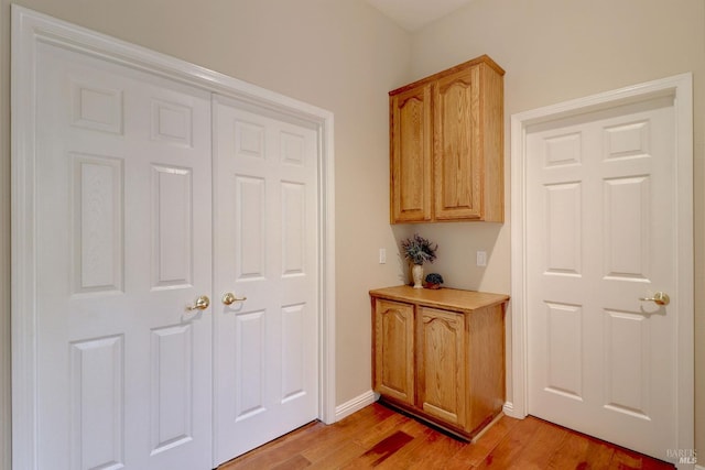 corridor with light hardwood / wood-style floors