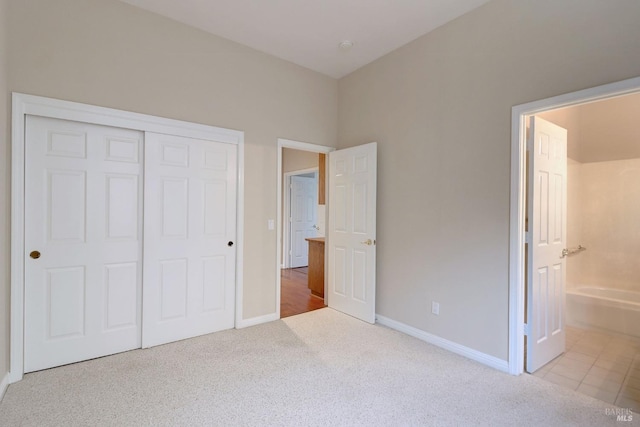 unfurnished bedroom with a closet and light colored carpet