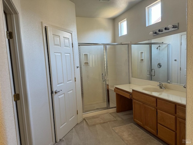 bathroom featuring vanity, a textured ceiling, and walk in shower