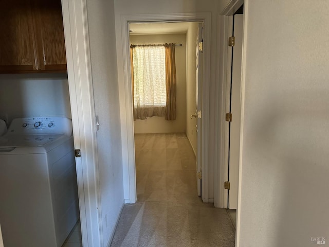 hallway with light carpet and washer / clothes dryer