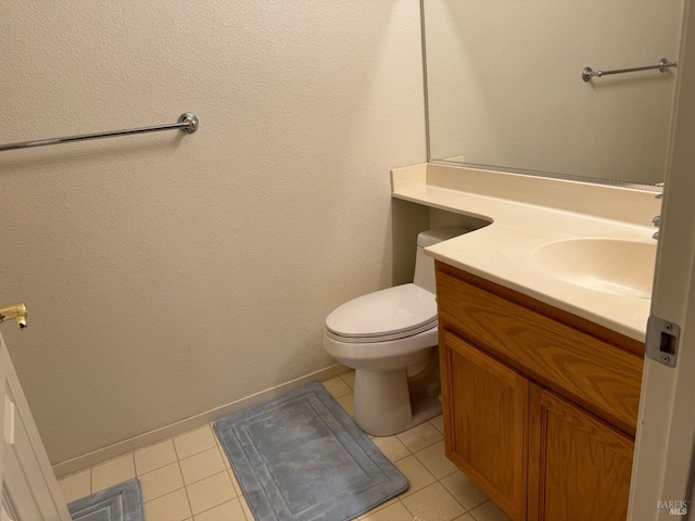 bathroom with tile patterned flooring, vanity, and toilet