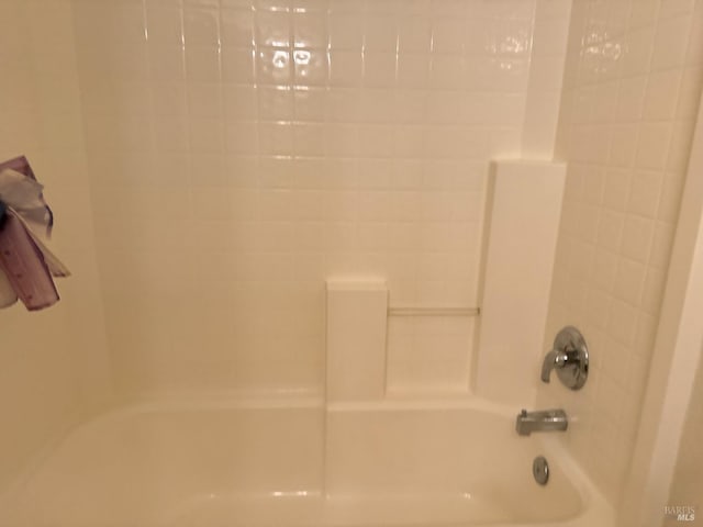 interior details featuring tiled shower / bath combo