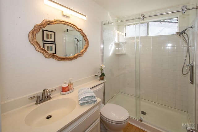 bathroom featuring vanity, toilet, and a shower with shower door