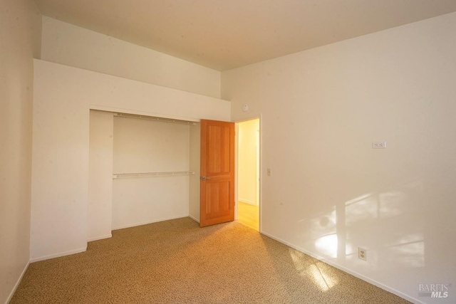 unfurnished bedroom featuring carpet flooring and a closet