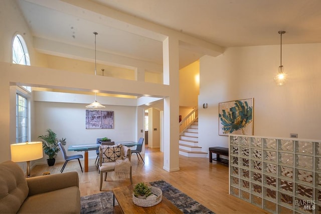 living room featuring beamed ceiling, wood-type flooring, and high vaulted ceiling