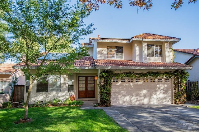 mediterranean / spanish house with a garage, a front yard, and french doors