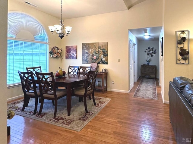 dining space with hardwood / wood-style floors and an inviting chandelier