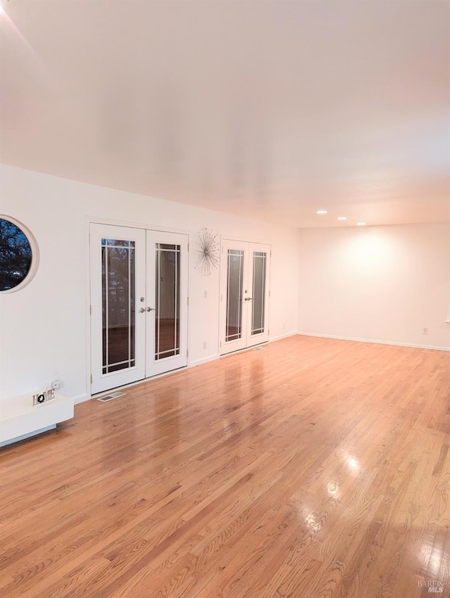 spare room with light hardwood / wood-style floors and french doors