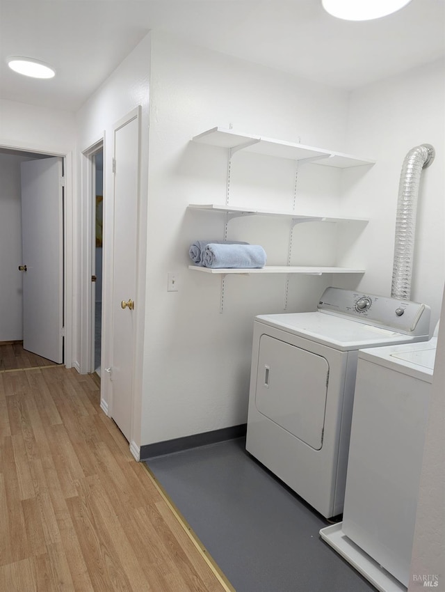 laundry room featuring separate washer and dryer and light wood-type flooring