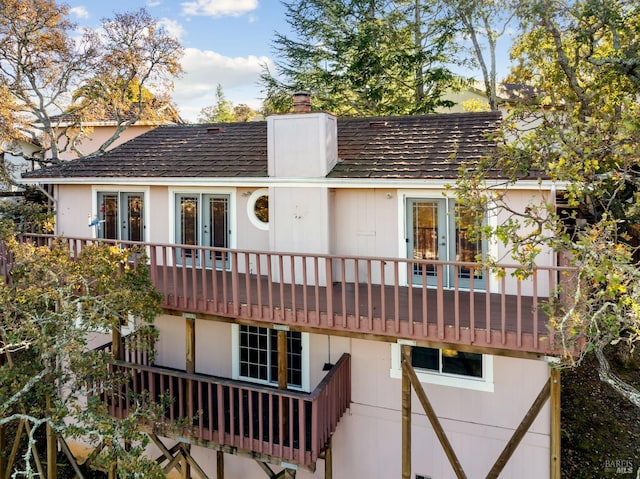 back of property featuring french doors and a balcony