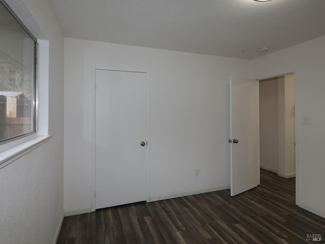 unfurnished bedroom featuring dark hardwood / wood-style flooring and a textured ceiling