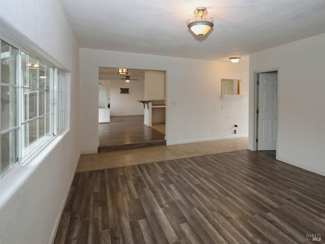 unfurnished room featuring ceiling fan and dark wood-type flooring