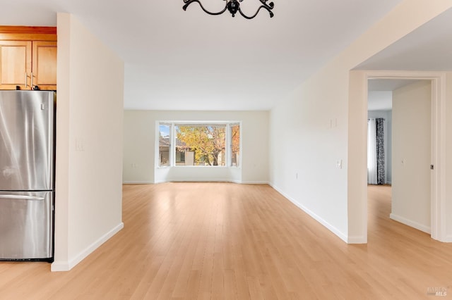 3473 Tice Creek Dr Unit 1, Walnut Creek, CA 94595 - unfurnished living room with a chandelier, light wood-style flooring, and baseboards