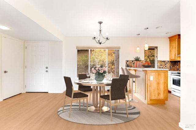 3473 Tice Creek Dr Unit 1, Walnut Creek, CA 94595 - dining space with light wood finished floors, a chandelier, and baseboards
