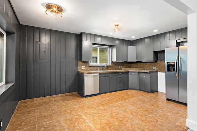 kitchen featuring gray cabinetry, stainless steel appliances, electric panel, and tasteful backsplash